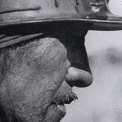 A black and white historical image of a coal miner.