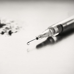 A needle sits next to a small pile of white powder heroin.