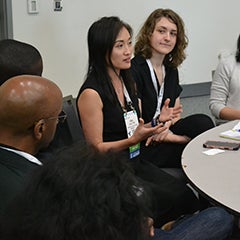 Faculty and students discuss health policy issues sitting around a table at the 2018 American Public Health Association conference.