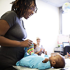 A mother plays with her baby at a post-natal clinic.