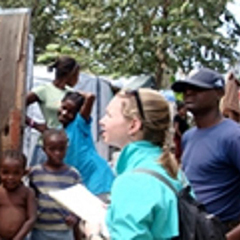 Heather Drummond holds a questionnaire as she asks questions of a man in Haiti as part of her research fieldwork.