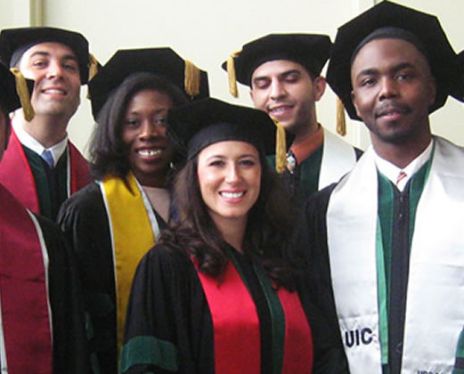 Graduates from various UIC health sciences degrees who are a part of the Urban Health Program pose for a photo with their graduation regalia.