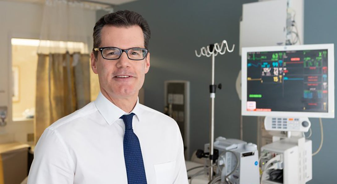 Dr. Stephen Trzeciak poses for a photograph in a hospital room.