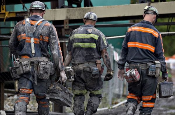 Coal miners walk together following a shift of work.