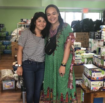 MPH students Kimberly Silva and Gabrielle Lodge pose for a picture standing in front of supplies they transported to Mississippi.
                  