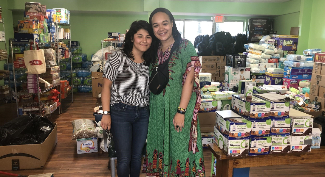 MPH students Kimberly Silva and Gabrielle Lodge pose for a picture standing in front of supplies they transported to Mississippi.