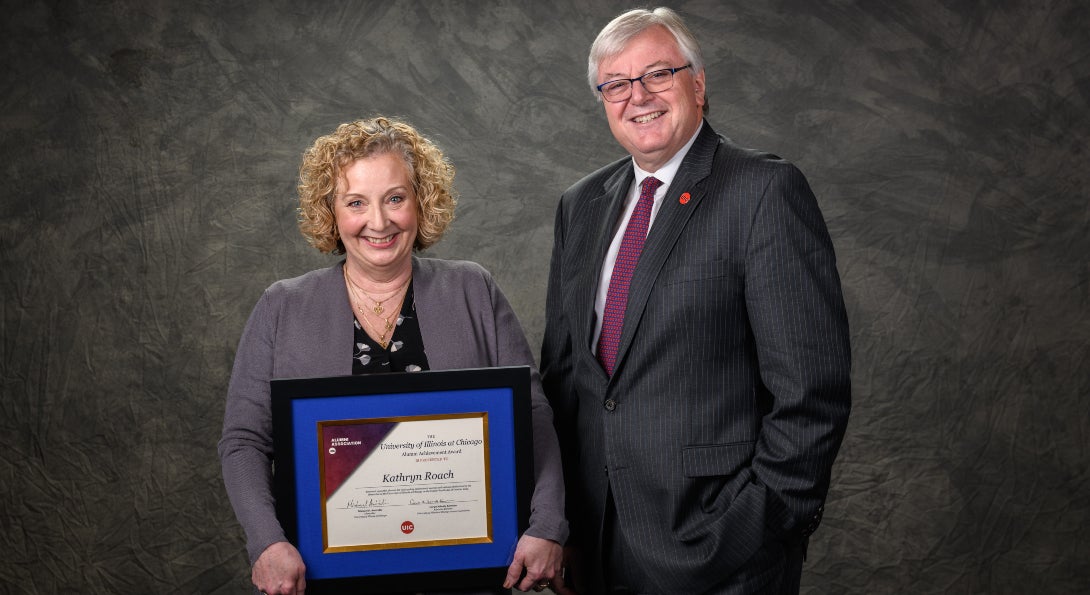 Kathryn Roach poses for a photo with Chancellor Michael Amiridis.  Kathryn is holding her award plaque.