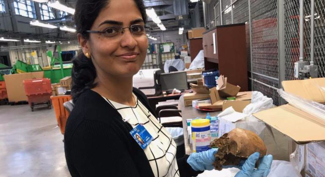 Sampada Mudgalkar poses for a picture while holding a human skull that was quarantined at O'Hare from a passenger's baggage.