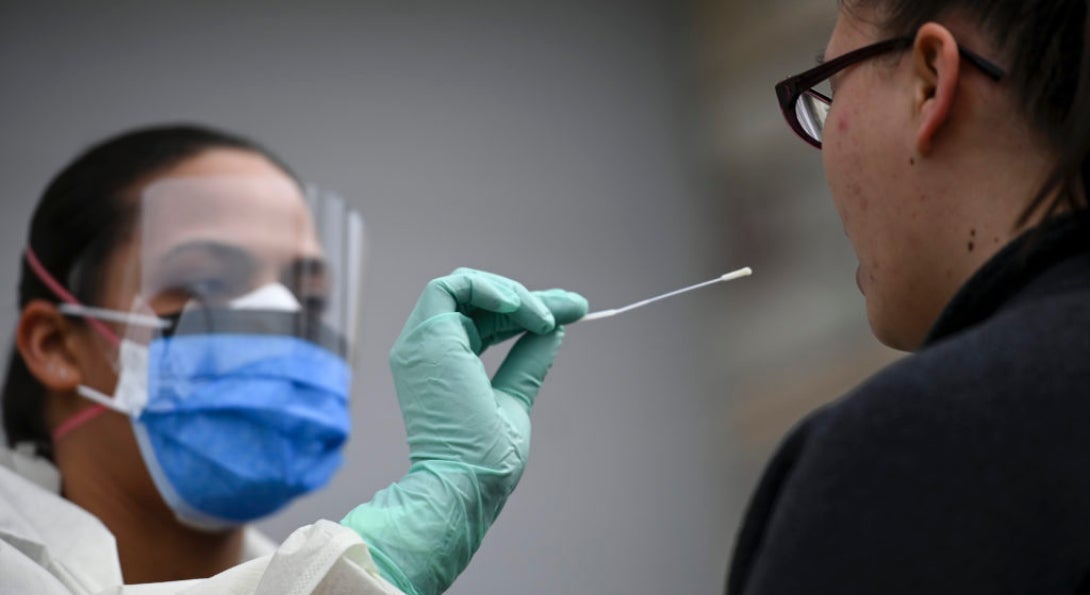 A medical professional administers a COVID-19 nasal swab test.