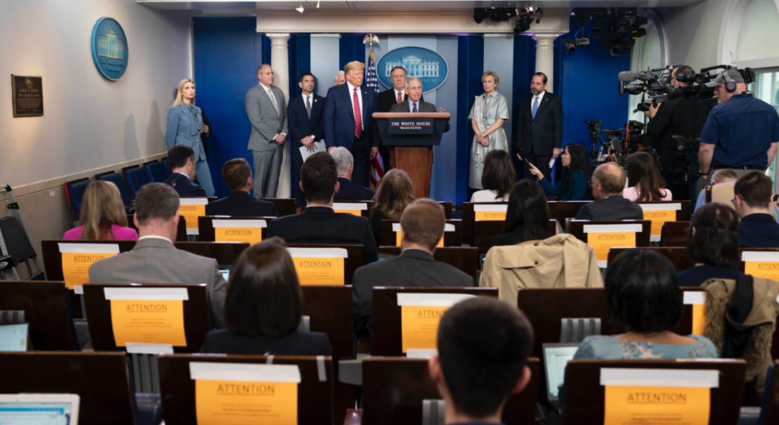Media practicing social distancing listen during a press conference at the White House.