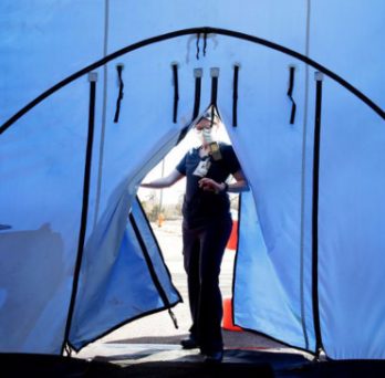 A nurse steps into a portable hospital tent set up in a parking lot in Naperville, Illinois. 