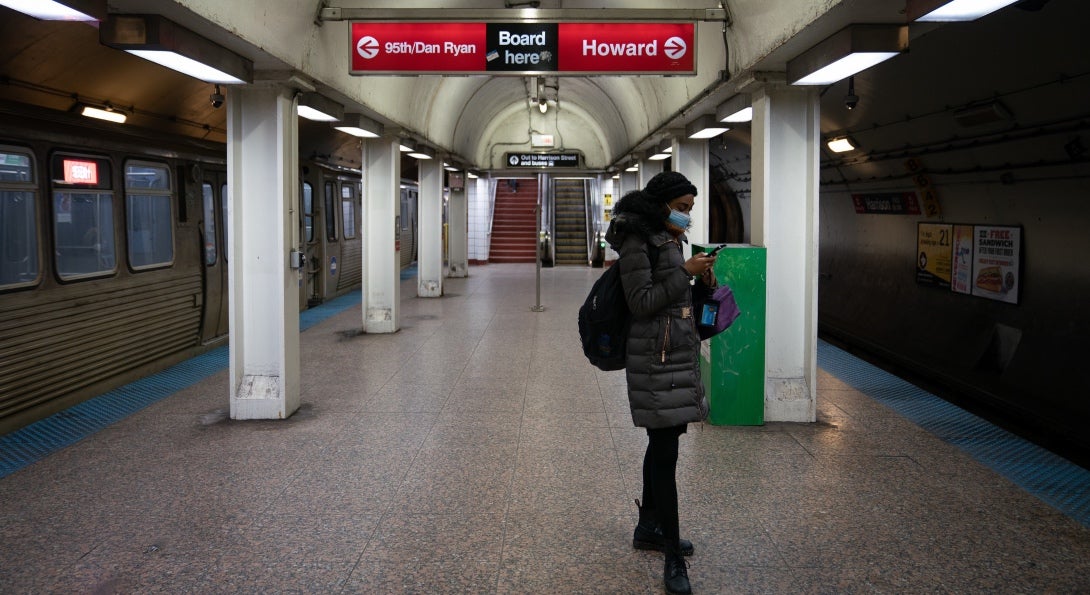 A solitary rider wears a mask while waiting for a CTA train at an underground station in Chicago.