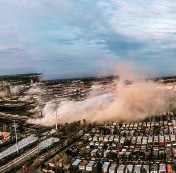 An aerial view of the demolition of a smokestack at the Crawford Generating Station, which generated a plume of dust that diffused through Chicago's Little Village neighborhood.
                  
