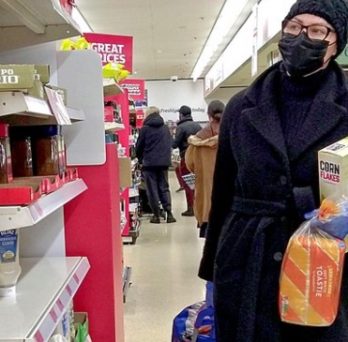 A woman wears a face mask while shopping for groceries. 