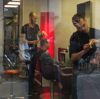 A barbershop in Paris, with a person getting a haircut. 