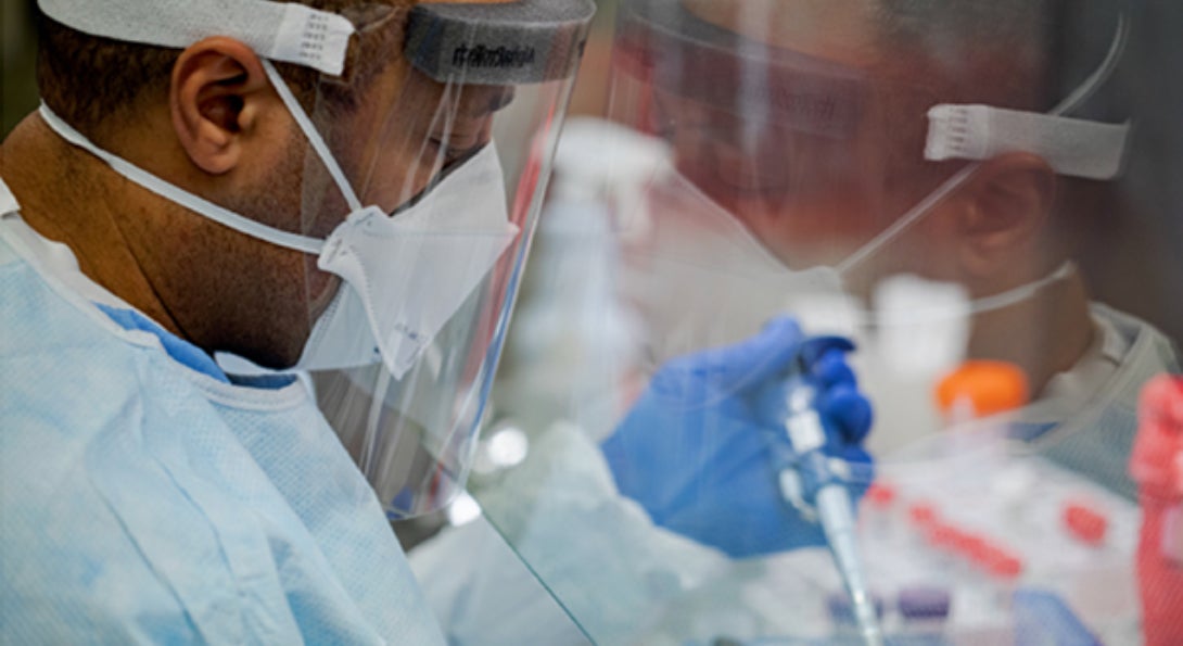 A lab technician processes a COVID-19 test.