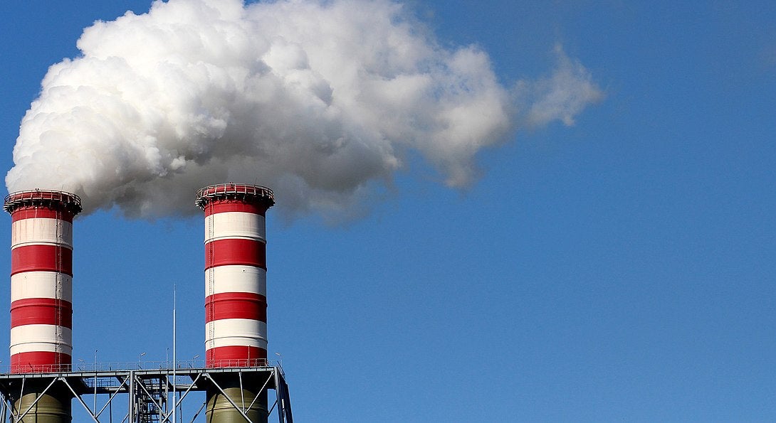 Two smokestacks emit white clouds of exhaust.