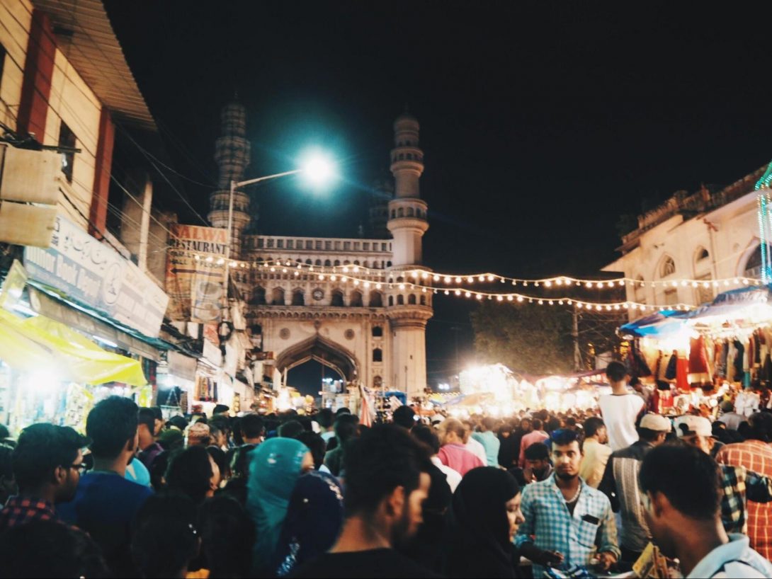 Photo 2. Charminar in the front of the photo. Street vendors and restaurants surround Charminar.