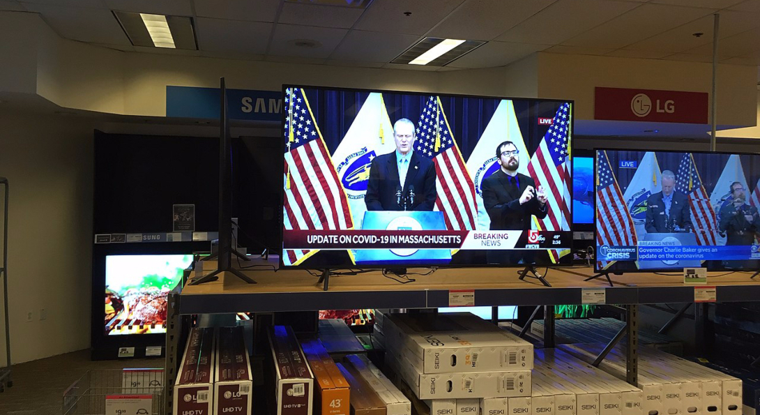 Flatscreen TVs for sale in a Cambridge, Massachusetts electronics store display Gov. Charlie Baker discussing the COVID-19 pandemic.
