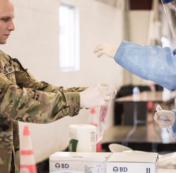 Illinois National Guard members process a COVID-19 test. 