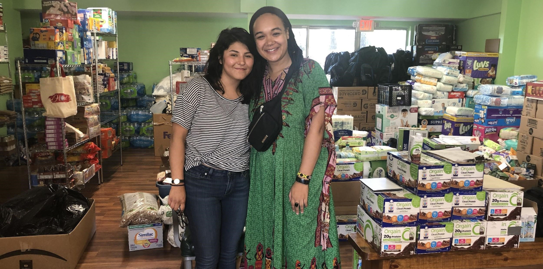 MPH students Kimberly Silva and Gabrielle Lodge pose for a picture standing in front of supplies they transported to Mississippi.