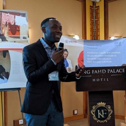 Tamah Kamlem stands in front of a room delivering a presentation in Senegal.