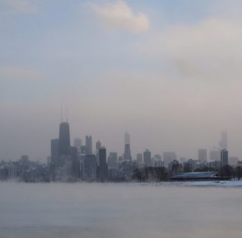 Fog rises from a frozen Lake Michigan and envelopes the Chicago Loop during the 2014 polar vortex.
                  