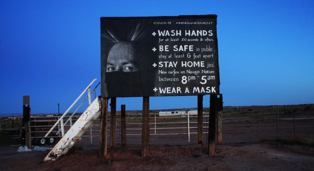 A sign posted on Navajo Nation territory reminds people to follow COVID-19 safety guidelines.