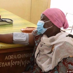 A patient at a healthcare clinic in Ghana has blood pressure checked.