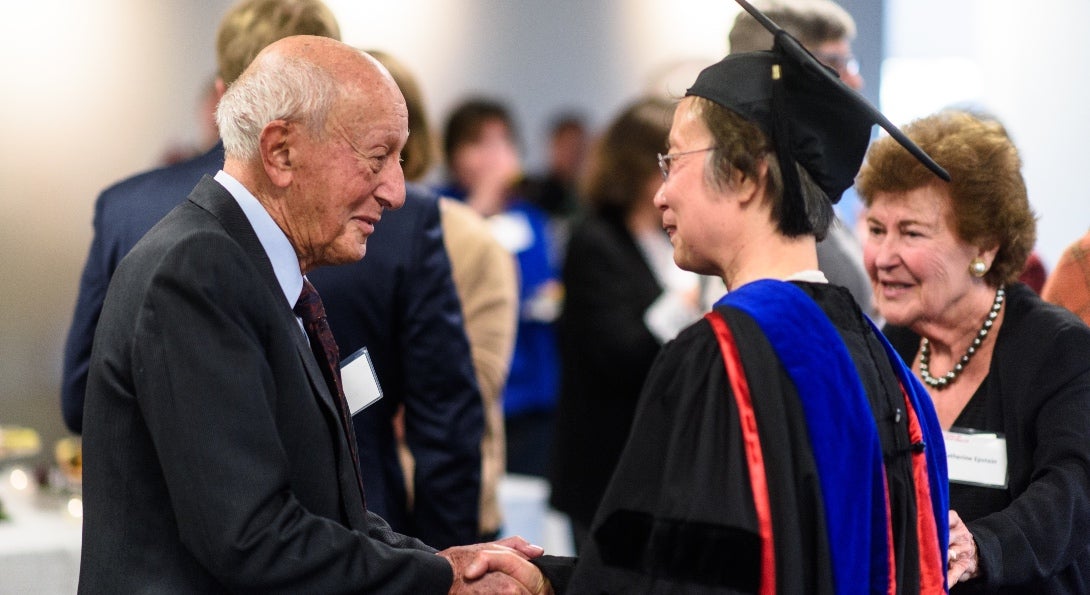 Dr. Samuel Epstein and Mrs. Catherine Epstein congratulate An Li.