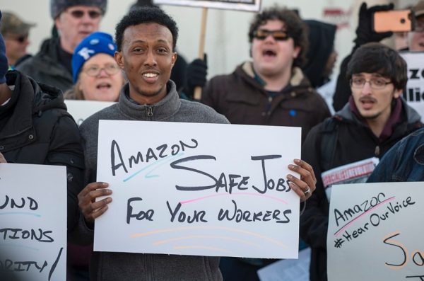 A group of workers hold signs while protesting outside an Amazon warehouse in Shakopee, Minnesota.