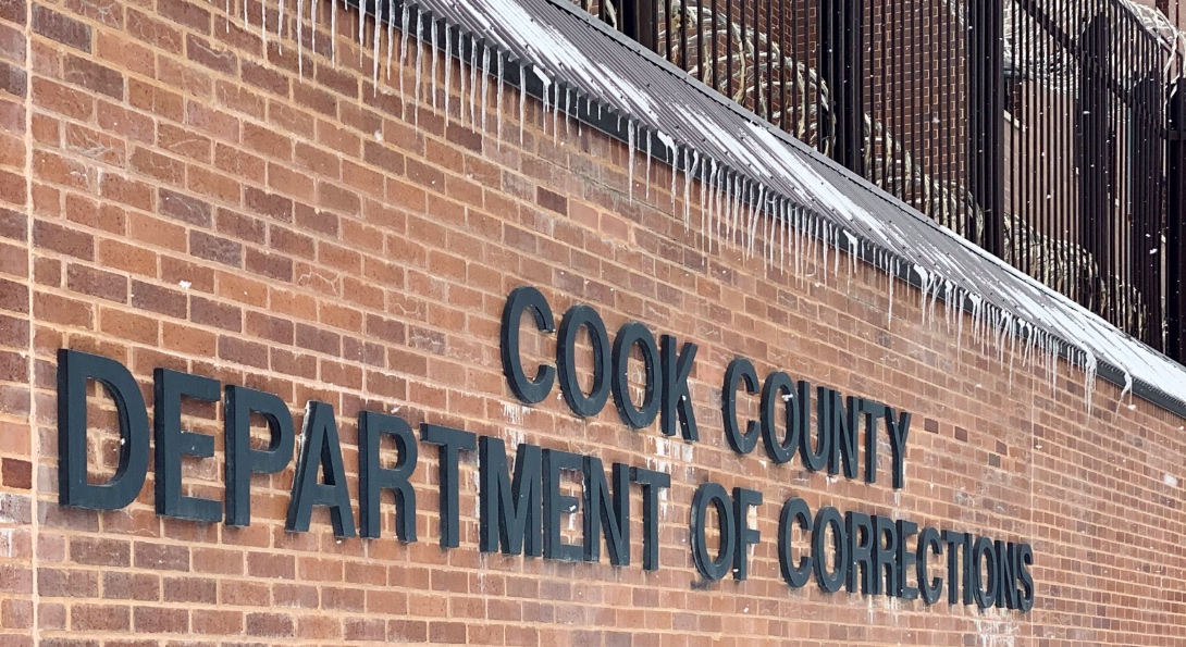 A sign on a brick wall for the Cook County Jail Department of Corrections.