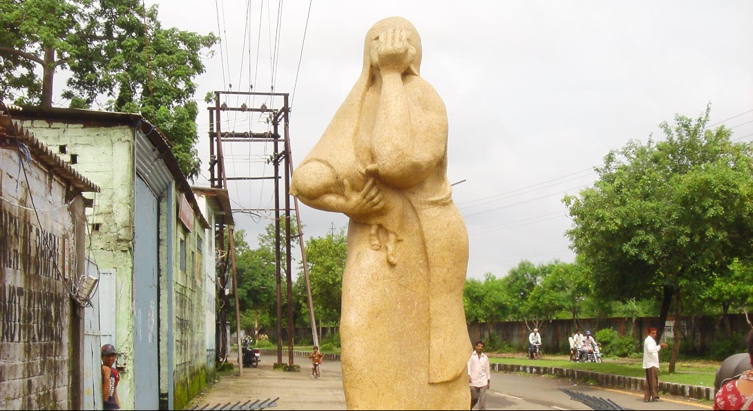 The Bhopal Mother statue in India, a golden statue of a mother covering her face in horror or sadness while she holds a child in her arms.