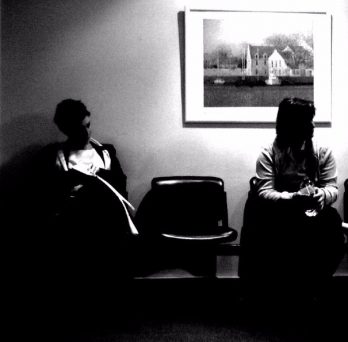 People sit in a doctor's office waiting room.
                  