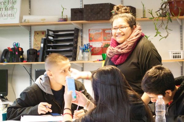 A teacher of Latina descent speaks to Latinx students in her classroom.