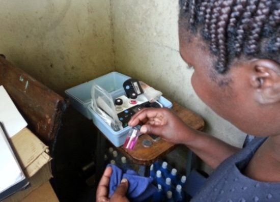 An MPH student examines water samples in small glass vials while abroad in Kenya.