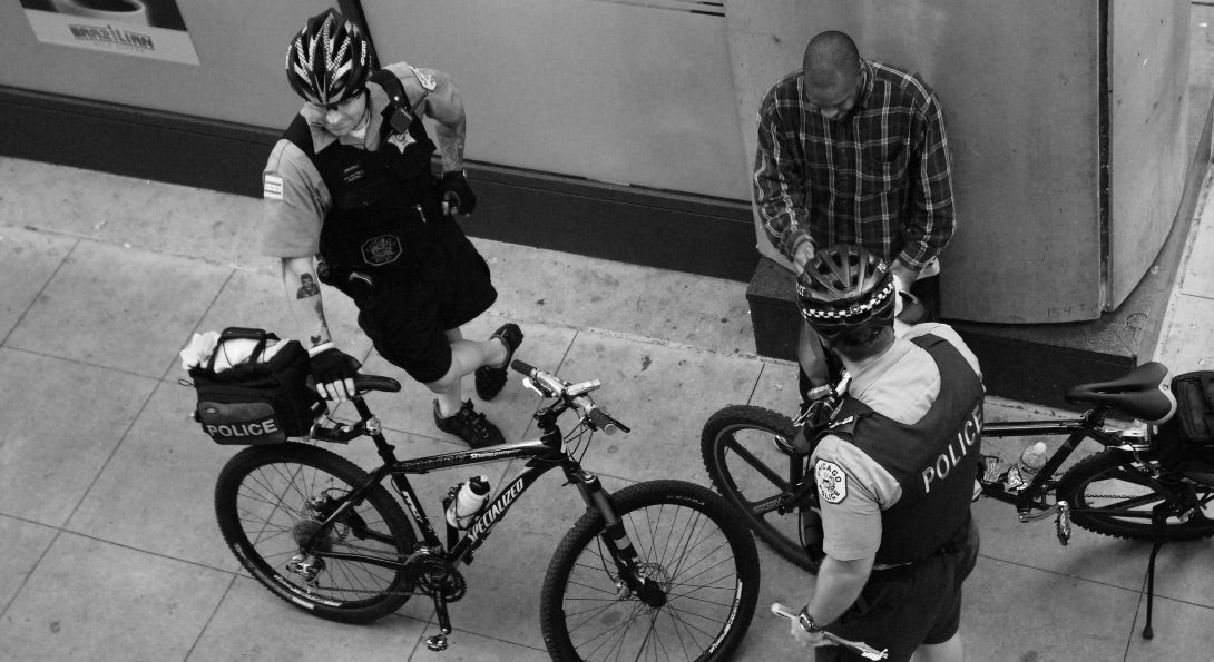 Chicago Police interact with a Chicago citizen on a street corner.