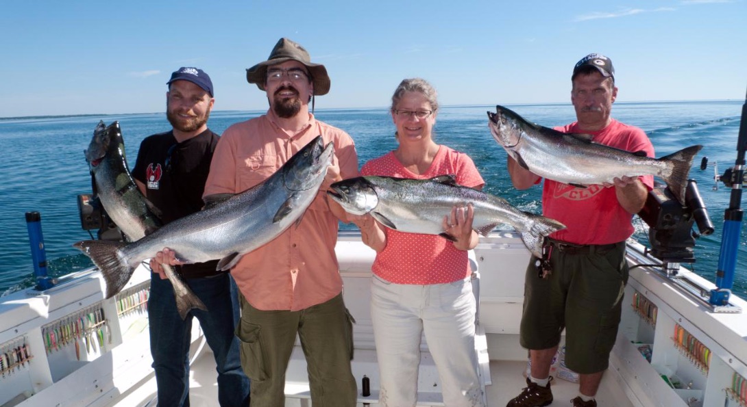 Charter boat customers hold up large fish they caught during their voyage.