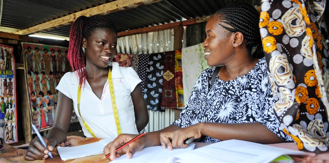 A health screener meets with a female worker in Kisumu to talk about personal health outcomes.