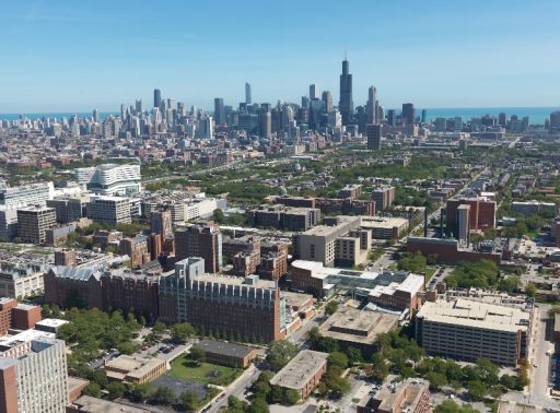 An aerial view of the Illinois Medical District, with the Chicago skyline and Lake Michigan in the background.