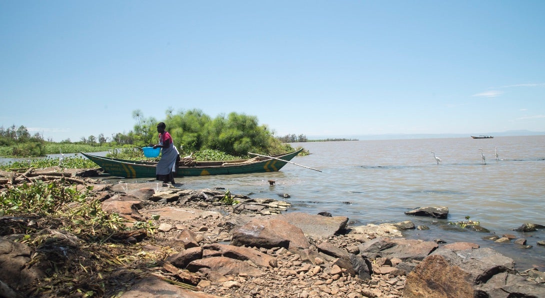 A woman fills a bucket with water from Lake Victoria in Kisumu County, Kenya.