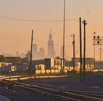A rail yard in Chicago, with the Chicago skyline in the background.
                  