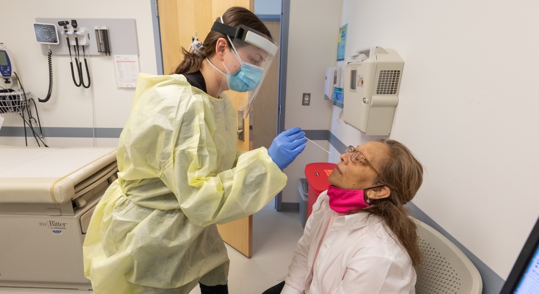 A healthcare professional inserts a nasal swab into the nose of a COVID-19 patient.