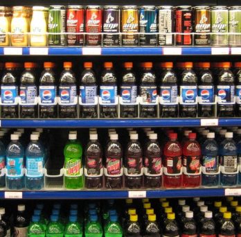 Rows of soda and other sweetened beverages at a grocery store.
                  