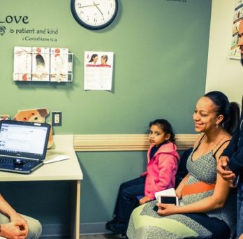 A doctor sees a family in an examination room at a federally qualified health center.
                  