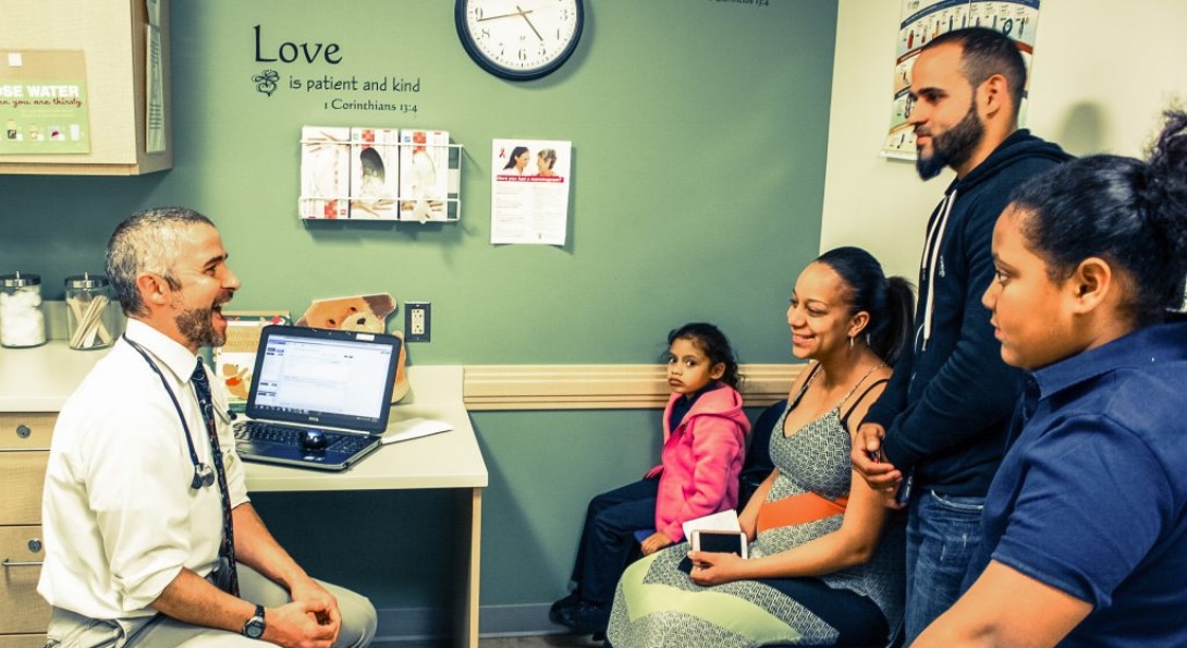A doctor sees a family in an examination room at a federally qualified health center.