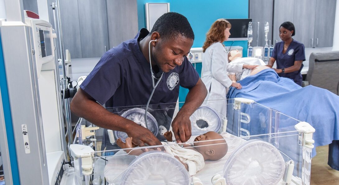 A UIC student takes part in a medical simulation lab working on a sim baby.