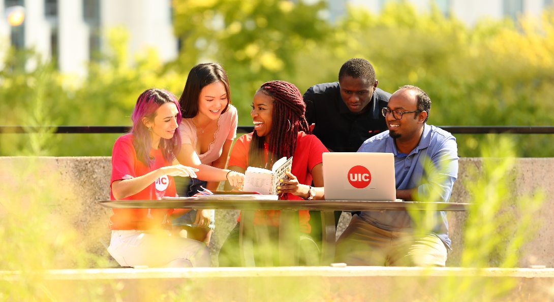 UIC students study together while sitting outside on UIC's campus.