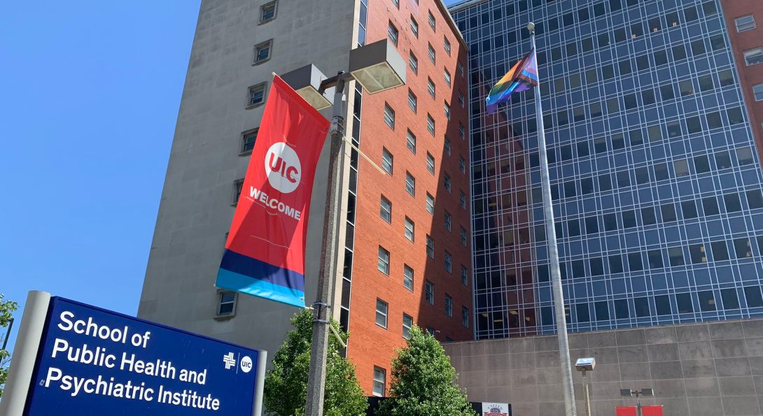 The School of Public Health building, with a rainbow flag flying on the flagpole in front of the building.