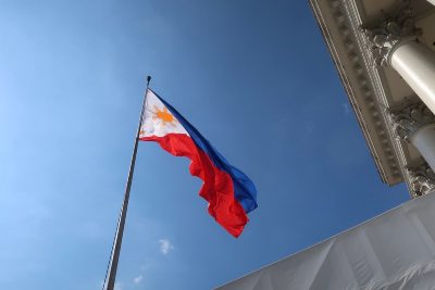 Philippines flag waving in front of a blue sky.